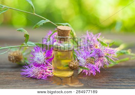 Essence Of Lavender Flowers On Table In Beautiful Glass Bottle