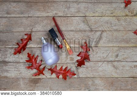 Perfume Bottle,lipstick,bruch On A Wooden Background With Autumn Red-orange Oak Leaves