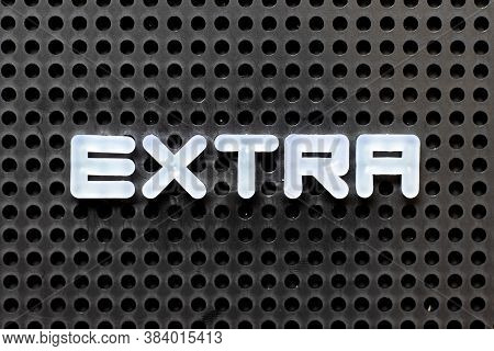 White Color Alphabet With Word Extra On Black Pegboard Background