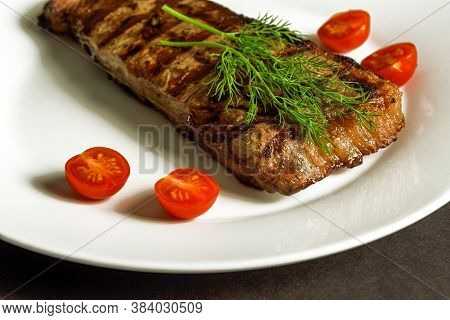 Steak Ribeye On The White Plate Whith A Tomatos