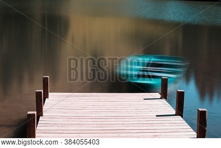 Long Exposure Of A Green Boat At A Pier In A Lake In The Swiss Alps Moving In The Wind