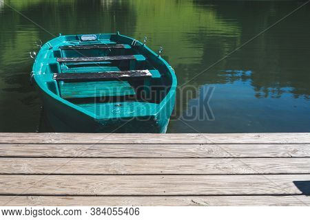 Closeup Of A Green Boat At A Pier In A Mountain Lake