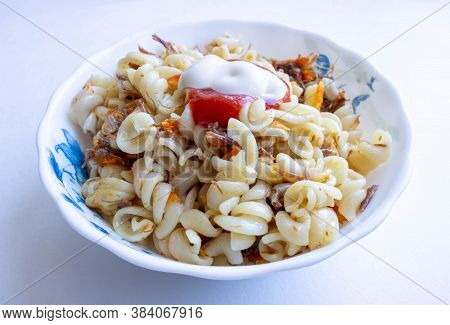 Traditional Soviet Russian Dish Of Pasta, Vermicelli, Sea Paste, With Meat On A White Plate On A Whi