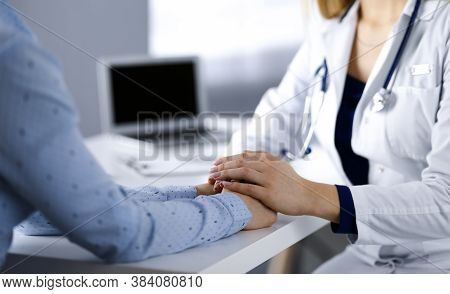 Unknown Woman-doctor Is Holding Her Patients Hands, Discussing Current Health Examination, While The