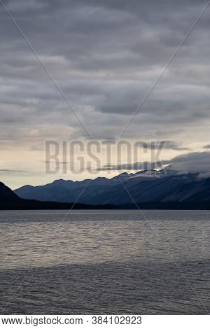 Beautiful View Of Muncho Lake In The Canadian Northern Rockies During A Cloudy Sunrise. Taken In Bri