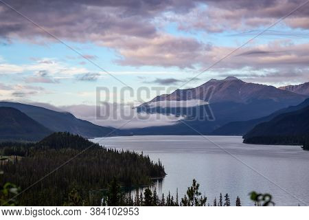 Beautiful View Of Muncho Lake In The Canadian Northern Rockies During A Cloudy Sunrise. Taken In Bri