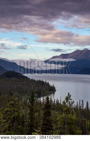 Beautiful View Of Muncho Lake In The Canadian Northern Rockies During A Cloudy Sunrise. Taken In Bri