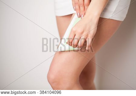 Beautician Waxing A Womans Leg Applying Wax Strip