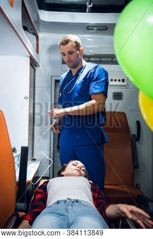 A Young Woman Is Getting Hospitalized, A Paramedic Is Preparing An Oxygen Mask For Her.
