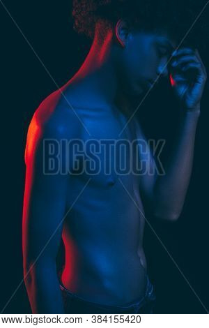 African Man Portrait. Neon Light.tired Black Male In Blue Red Glow With Shirtless Torso Touching For