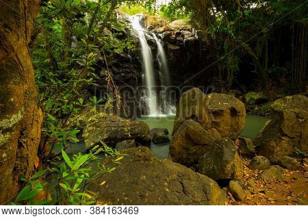 Tropical Landscape. Beautiful Hidden Waterfall In Rainforest. Foreground With Big Stones. Adventure 
