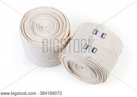 Two Modern Woven Elastic Medical Bandages With Aluminum Stretchable Clips Rolled Into Rolls On A Whi