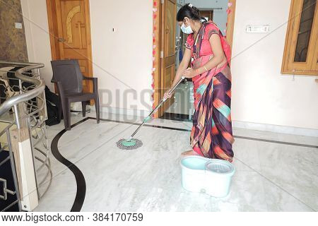 Indian Woman Wearing Mask Cleaning Floor With Mop Sanitizing. Mopping Floor At Home, Protection Agai