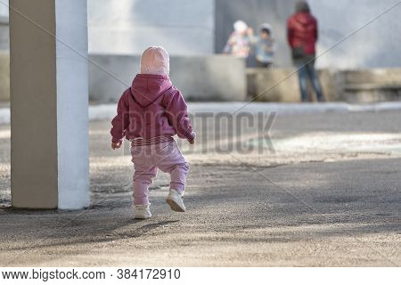 Toddler Runs To The Children. Little Girl Walking On The Street. Concrete Jungle And Children.