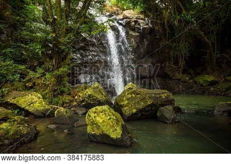 Tropical Landscape. Beautiful Hidden Waterfall In Rainforest. Foreground With Big Stones. Adventure 