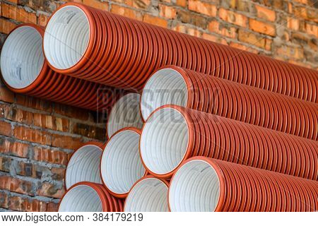 Warehouse Of Finished Plastic Pipes Industrial Outdoors Storage Site. Orange Pvc Pipes Stacked In Co