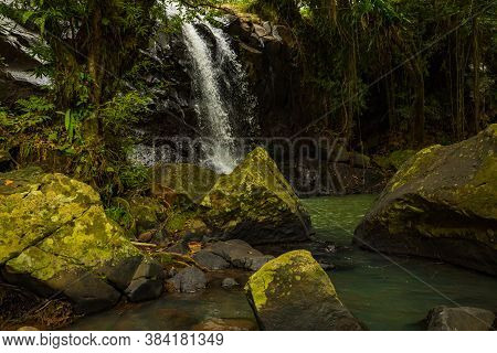 Tropical Landscape. Beautiful Hidden Waterfall In Rainforest. Foreground With Big Stones. Adventure 