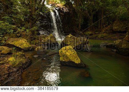Tropical Landscape. Beautiful Hidden Waterfall In Rainforest. Foreground With Big Stones. Adventure 