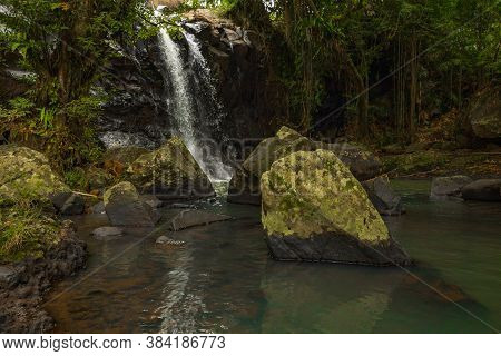 Tropical Landscape. Beautiful Hidden Waterfall In Rainforest. Foreground With Big Stones. Adventure 