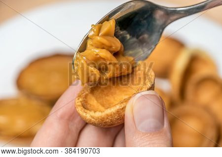 Filling The Halves Of Cookie Nuts With Boiled Condensed Milk. Women's Hands Fill Cookies With Boiled