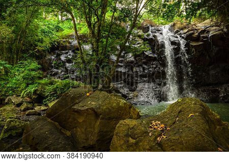Tropical Landscape. Beautiful Hidden Waterfall In Rainforest. Foreground With Big Stones. Adventure 