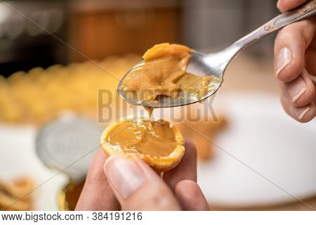Filling The Halves Of Cookie Nuts With Boiled Condensed Milk. Women's Hands Fill Cookies With Boiled