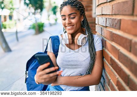 Young african american student woman smiling happy using smartphone at the university campus