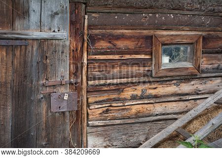 Cow Barn Wall With Small Window And With Door With An Old Rusty Lock