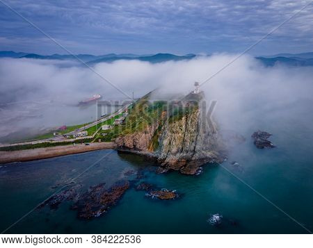 View From Above. Beautiful Cape Briner With Rudny Lighthouse On The Background Of Morning Fog