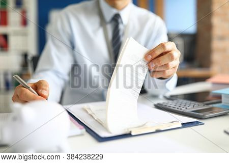 Close-up Of Accountant Specialist Sitting In Modern Office With Calculator And Paper Checks. Man In 