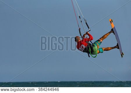 Kitesurfing on the waves of the sea in Mui Ne beach, Phan Thiet, Binh Thuan, Vietnam. Kitesurfing, Kiteboarding action photos. Kitesurf - backroll transition