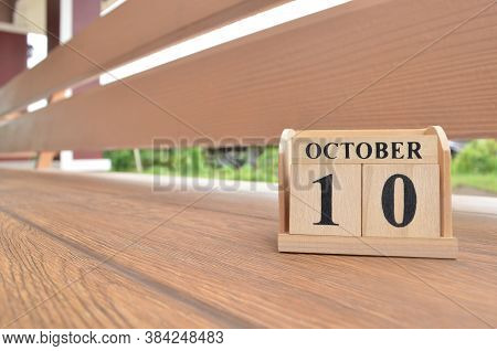 October 10, Number Cube With Wooden Balcony Background.