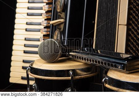 Old Accordion, Harmonica, Bong And Microphone On A Rustic Wooden Surface With Black Background And L