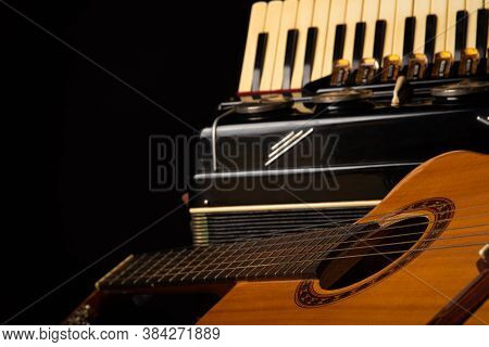 Old Accordion And A Beautiful Guitar Composing A Scene On A Rustic Wooden Surface With Black Backgro