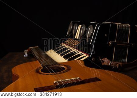 Old Accordion And A Beautiful Guitar Composing A Scene On A Rustic Wooden Surface With Black Backgro