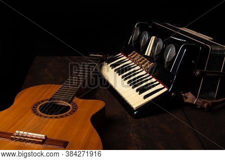 Old Accordion And A Beautiful Guitar Composing A Scene On A Rustic Wooden Surface With Black Backgro