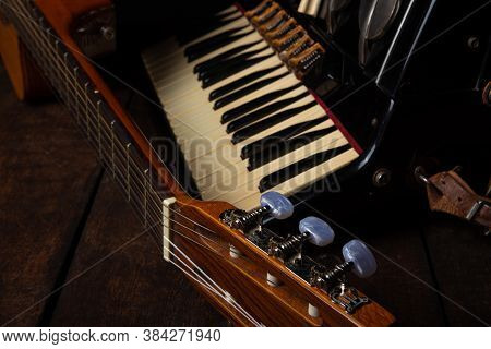 Old Accordion And A Beautiful Guitar Composing A Scene On A Rustic Wooden Surface With Black Backgro