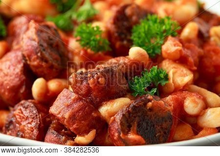 Bean And Chorizo Stew Served In White Bowl With Parsley