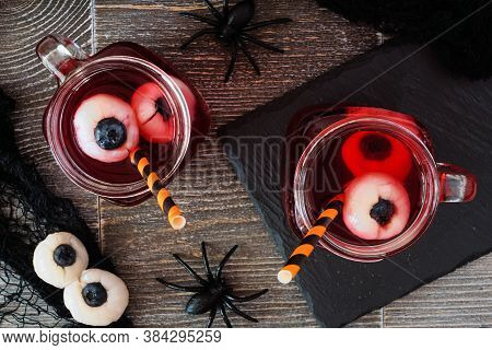 Spooky Halloween Eyeball Fruit Punch In Mason Jars. Top View Against A Dark Wood Background.