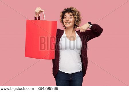 Cheerful Beautiful Young Woman In Blue Shirt With Curlty Hairstyle Standing And Pointing Finger To S