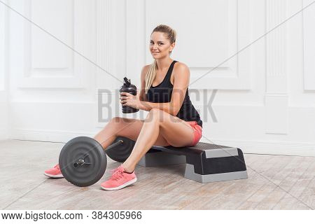 Portrait Of Happy Beautiful Young Athletic Causcasian Woman Pink Shorts And Black Top Siting And Hav