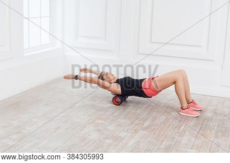 Beautiful Athletic Young Woman In Fashionable Fit Wear Using Foam Roller In Gym To Workout To Remove