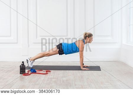 Side View Of Muscular Sporty Strong Young Athletic Beautiful Caucasian Woman In Black Shorts And Blu