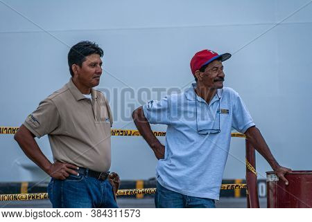 Corinto, Nicaragua - November 27, 2008: Closeup Of 2 Dock Workers At Harbor Carrying Shirt With Name