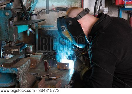 Electric Welding Process. Worker In Welding Mask. Bright White And Blue.