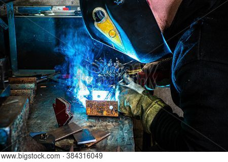 Electric Welding Process. Worker In Welding Mask. Bright White And Blue.