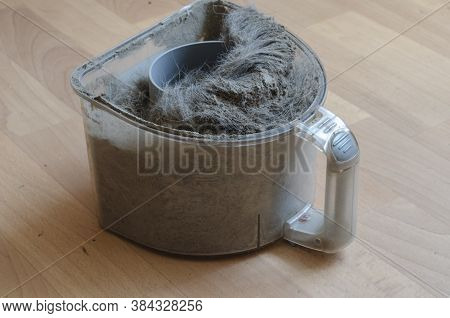 Vacuum Cleaner Container With Garbage. A Plastic Waste Container Full Of Dust And Wool. Cleaning Ser