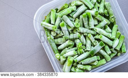Frozen Green Beans In A Plastic Container For Long-term Storage. Deep Freezing Of Vegetables. Frozen