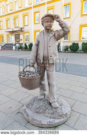 Varena, Lithuania - September 7 2020: Stone Statue Of Boy With Wicker Basket Full Of Mushrooms In Va