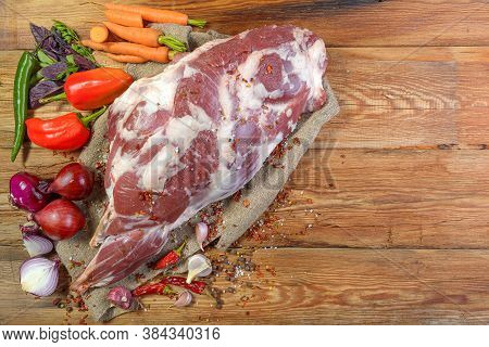 A Raw Leg Of Mutton On A Bone Lies On A Piece Of Burlap , Onions, Garlic, Pepper, Salt, Rosemary And